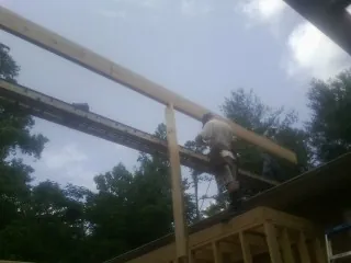 Carpenter setting a ridge beam over a new addition frame — Ice Dam Removal by Roofing Brothers in Hartleton