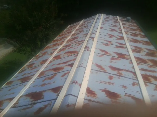 Rusted metal roof panels with new wood purlins before replacement — Storm Damage Roof Repair in Hartleton by Roofing Brothers