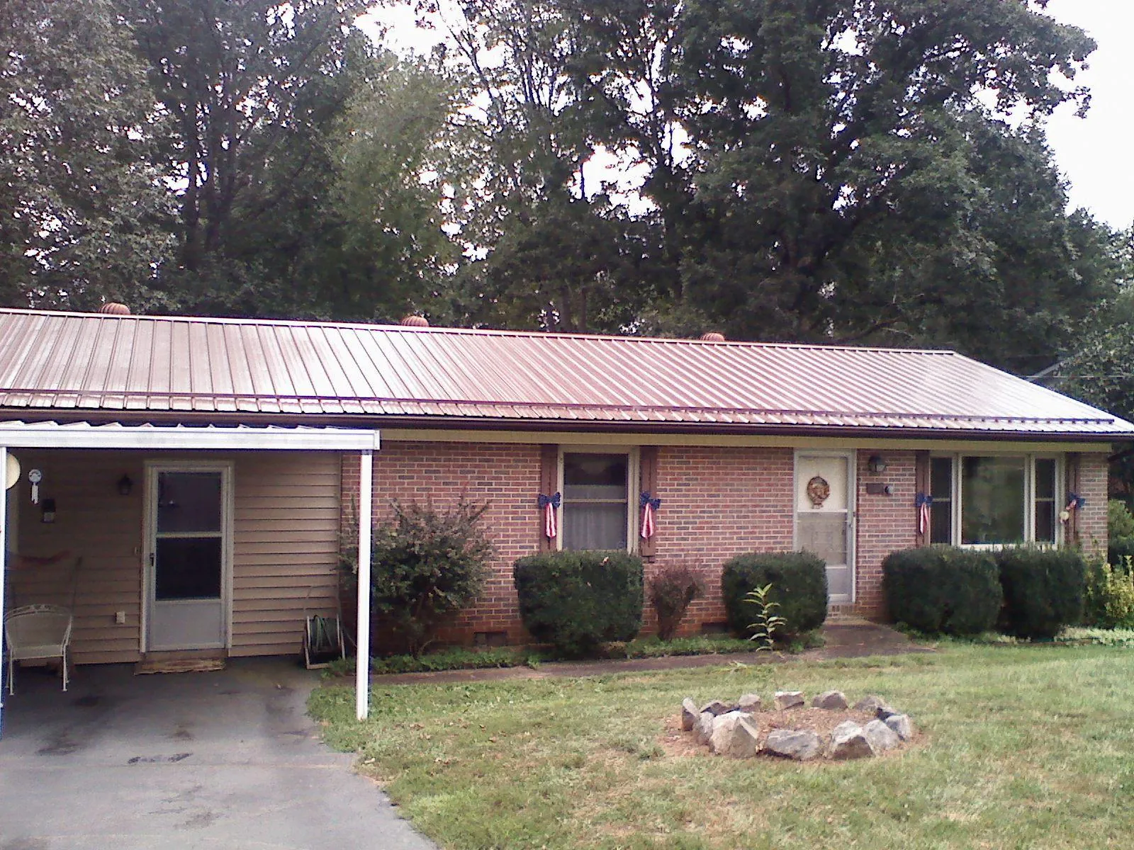 Bronze metal roof and carport on a brick ranch home — Roof Repair work by our crew in Hartleton